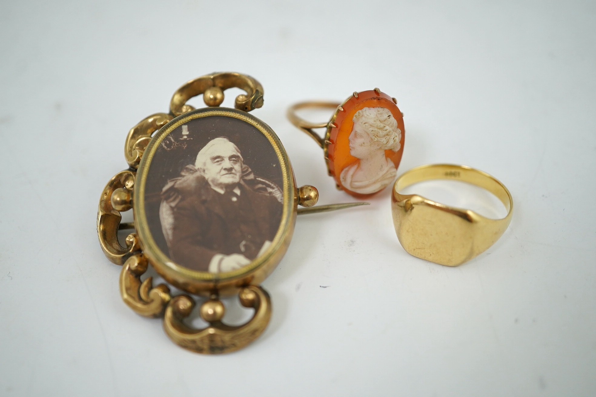 A yellow metal signet ring, stamped 18ct., 5.1 g, a cameo ring, indistinct Mark, 4.46 g gross and a reversible brooch. Condition - incomplete otherwise fair